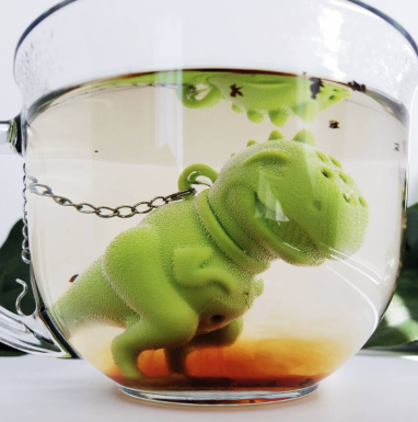 tyrannosaurus rex shaped silicone tea strainer in a glass mug